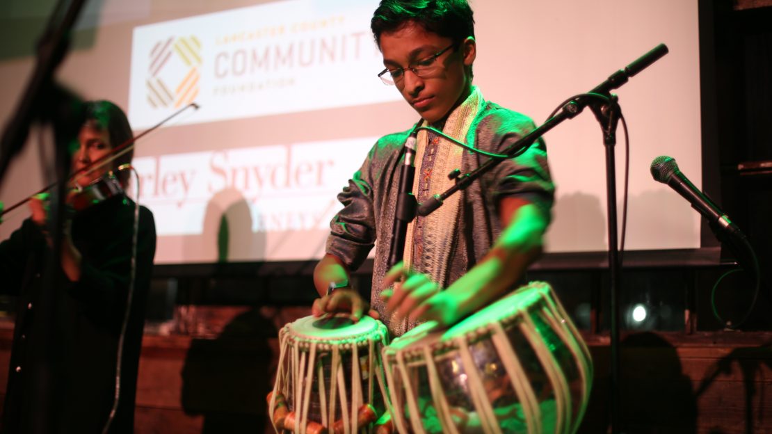Child plays on drums at event