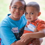 young boy holding younger brother on lap