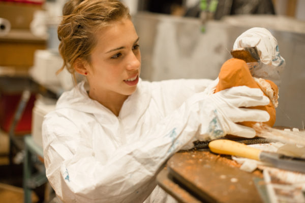 young girl carving a bird