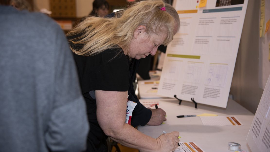 Woman writes her name on sign up sheet