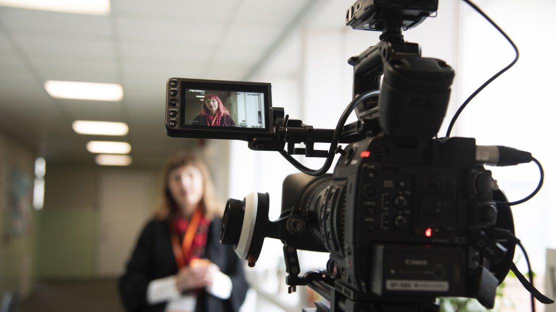 Close up of video camera recording a woman speak