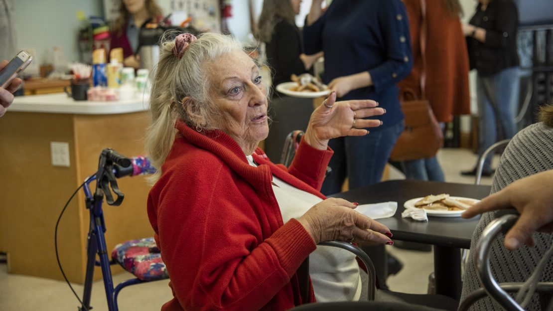 Close up of woman in red jacket talking to someone off screen