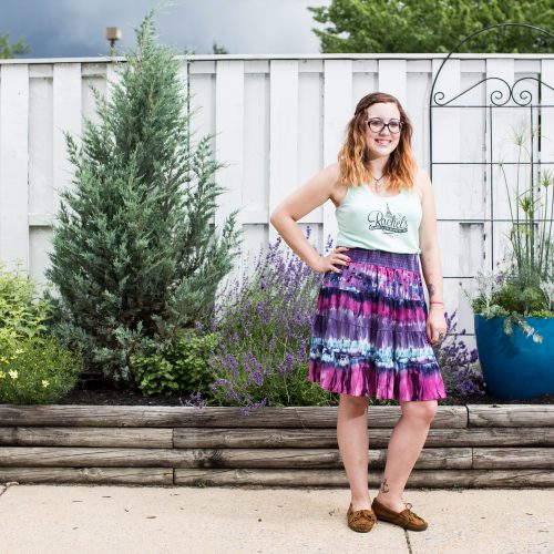 Daniella from Rachel's Cafe poses in front of a fence