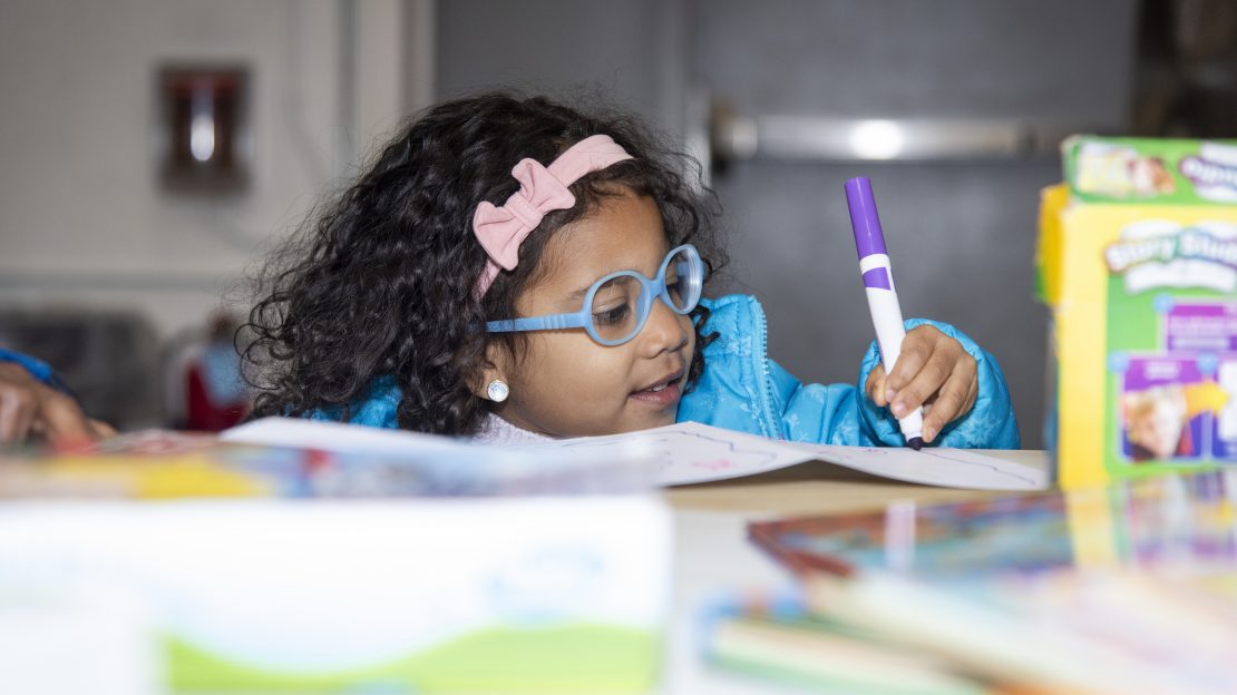 Small child uses a marker to color