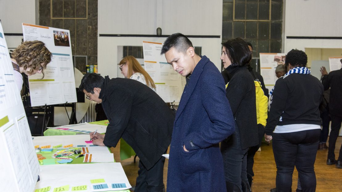 Group of people stand around table