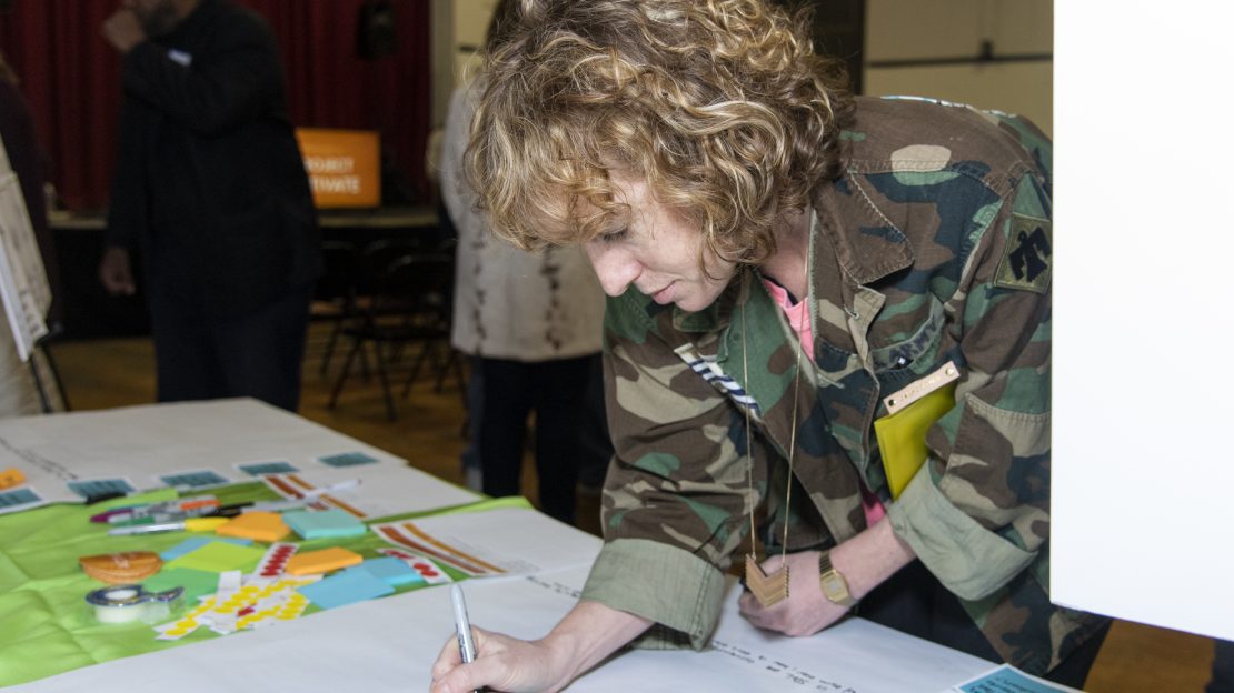 Woman writes on blue post it note