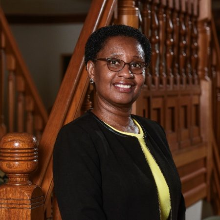 Portrait of woman standing near wooden stairs and smiling