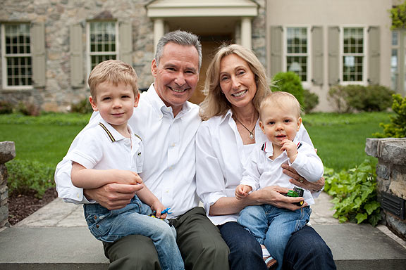 Saxton family sits on steps in front of house.