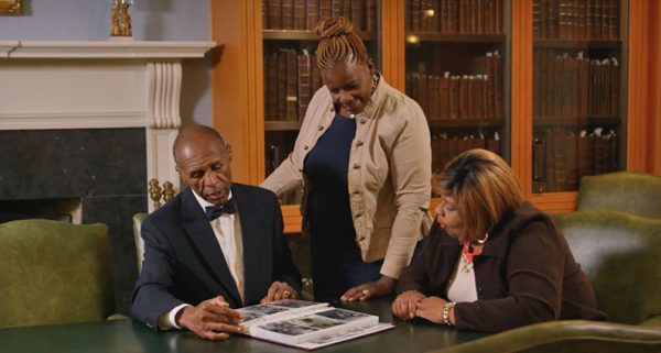 Three members of the Polite family look at photo album