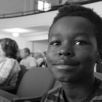 photo of a young child sitting in an auditorium