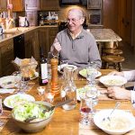 photo of people sitting around a dining room table eating