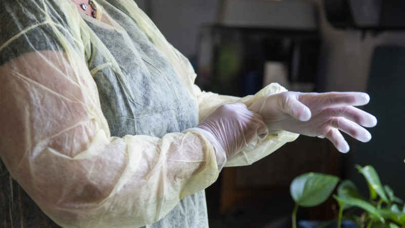 Photo of individual securing PPE on herself