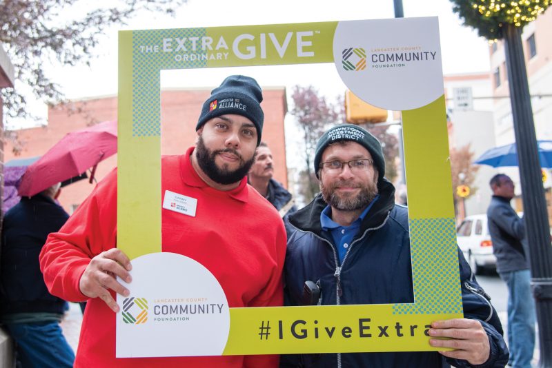 Two men smile with extra give frame