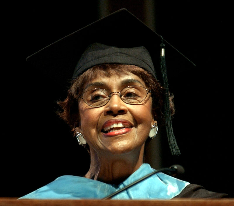 This picture shows Hazel Jackson, Professor Emeritus, in university attire and smiling.