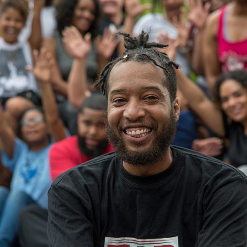 Picture of man smiling with a group of people in the background