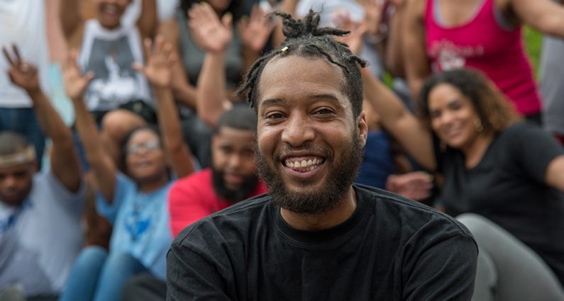Picture of man smiling with a group of people in the background