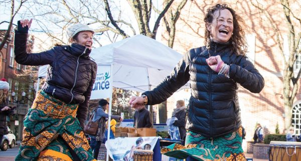 Two women dancing and laughing at perks for donors event