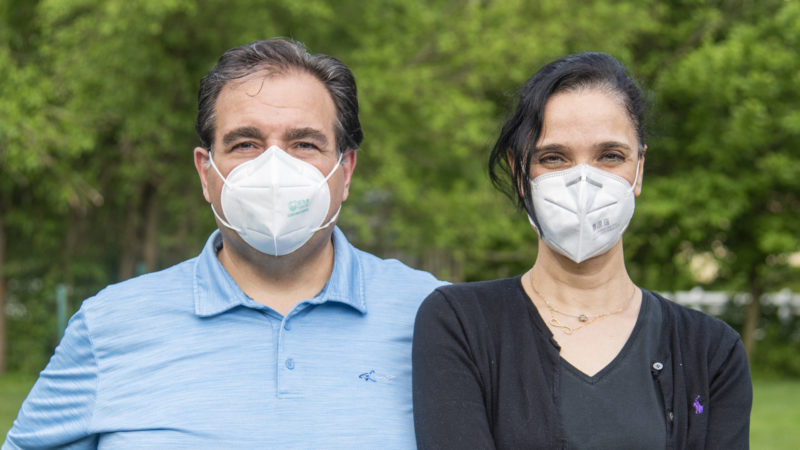 Two masked individuals smile for the camera
